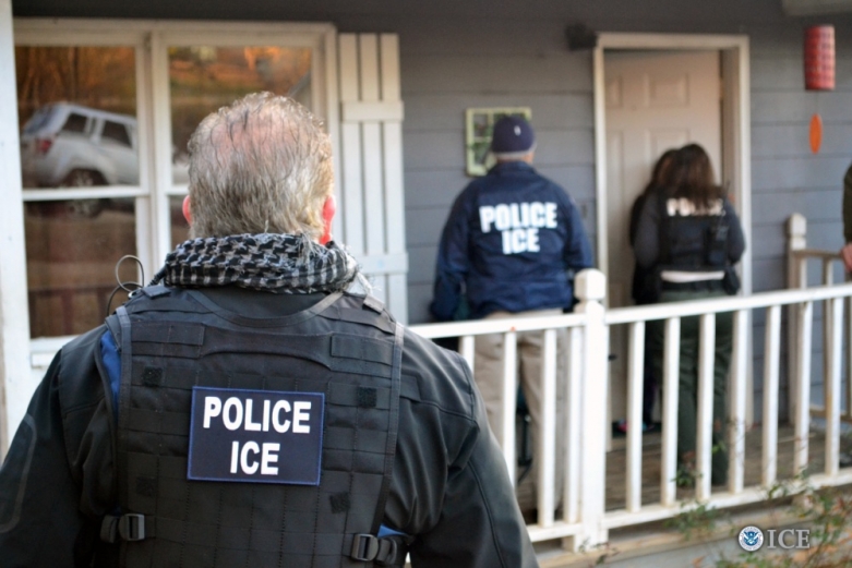 ICE agents standing in front of a home, knocking on the door. 