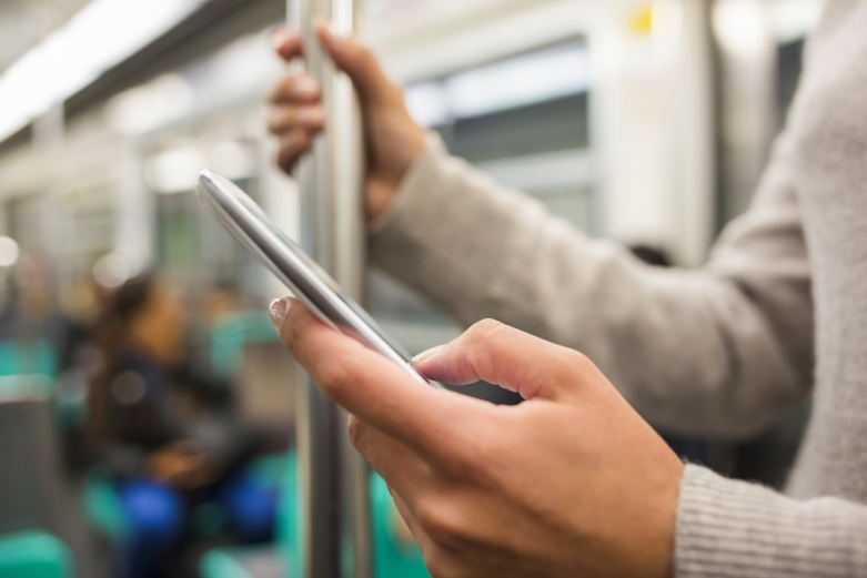 person on a cell phone on the subway