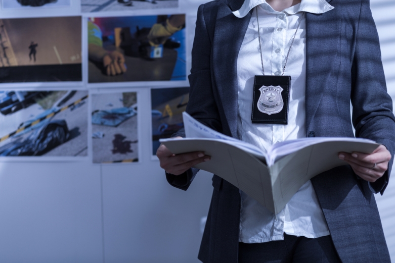 police officer holding files - shutterstock