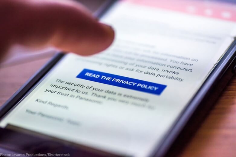 A photograph of a person scrolling on their phone to read the privacy policy of a website