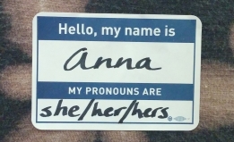 A name tag. It says: Hello, my name is Anna. My pronouns are she/her/hers