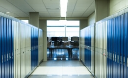 empty school hallway with lockers and an empty classroom at the end