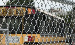 School Bus Parked Behind Chain Link Fence