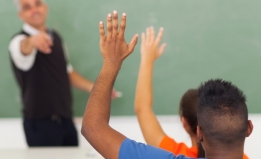 Students raise hands in classroom