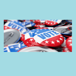 A photo of red, white, and blue buttons that say vote. 